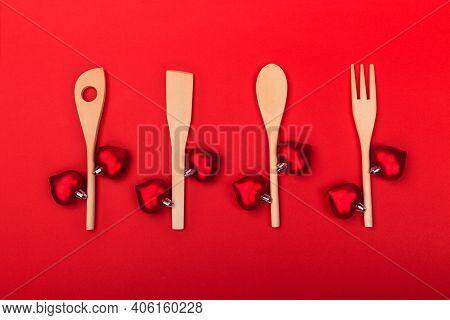 Wooden Kitchen Utensils With Red Hearts On Red Background. Cooking Spoon, Spatula And Fork Like Bran