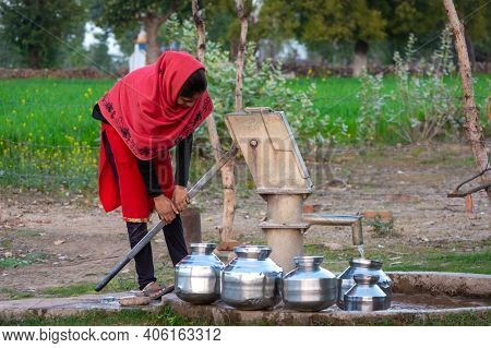 Tikamgarh, Madhya Pradesh, India - January 23, 2021: Unidentified Indian Girl Using Hand Pump For Dr
