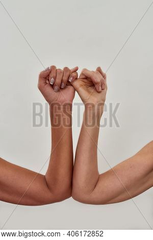 Close Up Shot Of Pinky Swear. Promise Hand Gesture Isolated Over Light Background. Vertical Shot