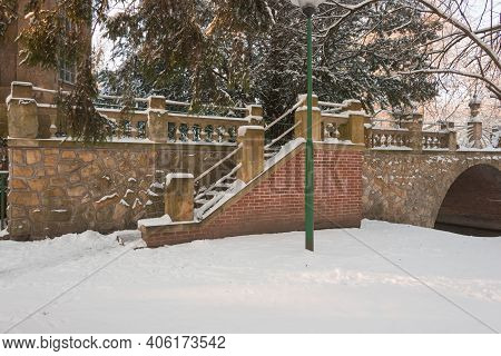 Manor Park In Iłowa In Winter. A Brick Bridge Over The Czerna Mała River.\nthe Town Of Iłowa In West