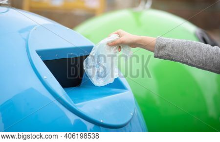Zero Waste Concept. Unrecognizable Woman Throwing Single Use Plastic Bag Into Blue Recycle Bin Outdo