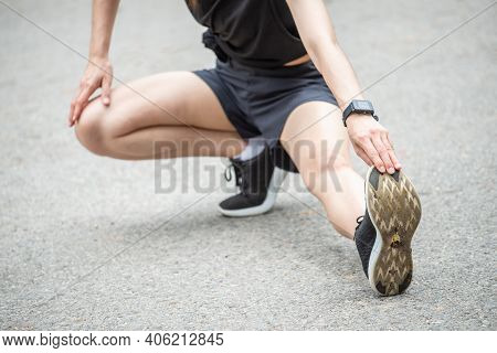 Cropped Shot View Of Runner Woman Doing Stretching And Warming Up Her Legs Before Running. The Benif