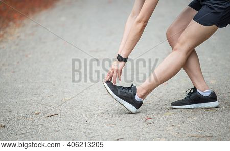 Cropped Shot View Of Runner Woman Doing Stretching And Warming Up Her Legs Before Running. The Benif