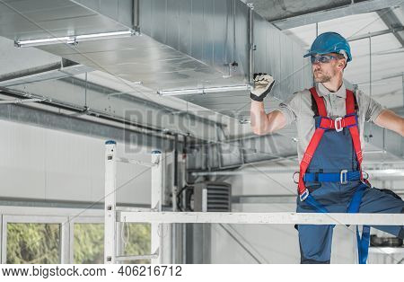 Caucasian Hvac Professional Worker In His 40s Checking Last Points Of The System From Aluminium Scaf
