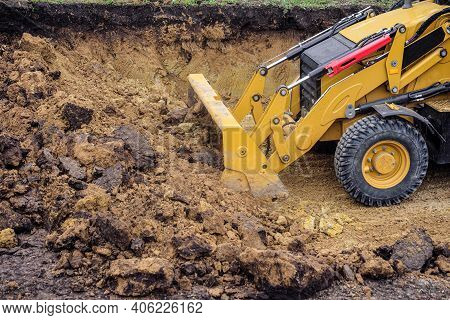 Loader Excavator With Backhoe Planning And Cutting Clay Ground At Eathmoving Works In Construction S