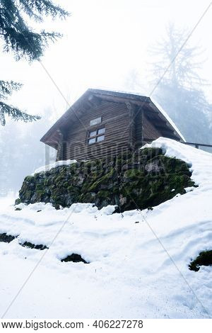 Log Cabin Hidden In Foggy Winter Forest