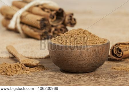 Cinnamon Powder And Cinnamon Stick; Photo On Wooden Background.