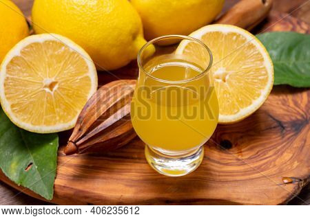Glass Of Ice Cold Sweet Limoncello Liqueur Made From New Harvest Of Fresh Ripe Yellow Italian Lemons