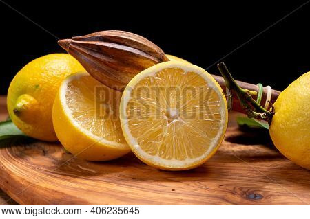 Fresh Ripe Yellow Italian Lemons And Wooden Juice Squeezer, New Harvest, On Olive Tree Wood Backgrou