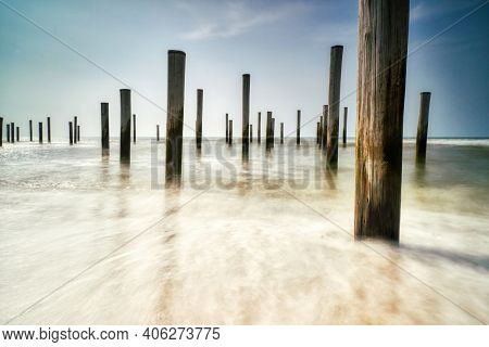 Long Exposure Seascape. Taken At The North Sea In Petten With The Pole Village In The Sea, Blue Sky,