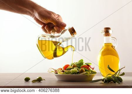 Man Dressing A Mediterranean Salad Of Fresh Vegetables On A Wooden Kitchen Bench White Isolated Back