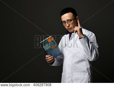 Young Man Doctors In White Medical Uniform Gown Stands Holding Professional Books With Blank Cover I
