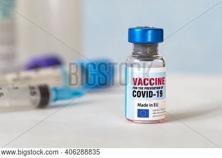 Medical Glass Vial And Plastic Syringe For Injection On White Table With Blue Gradient Background. C