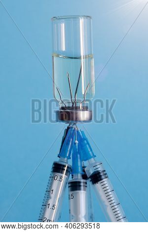 A Vertical Close - Up Image Of A Medicine Ampoule Turned Upside Down And Five Medical Needles Stuck 