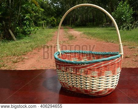 A modern handmade colourful rattan basket with handles. Blurred background