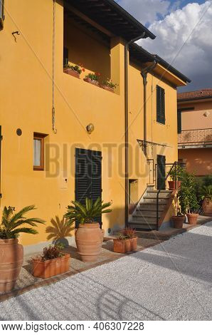 Bright Orange Yellow Apartment House In Europe. Planters And Courtyard.
