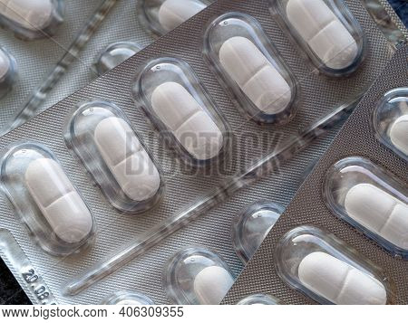 Oblong White Tablets In Blisters Close-up. Medical Background With Medicines For Pharmacies, Clinics