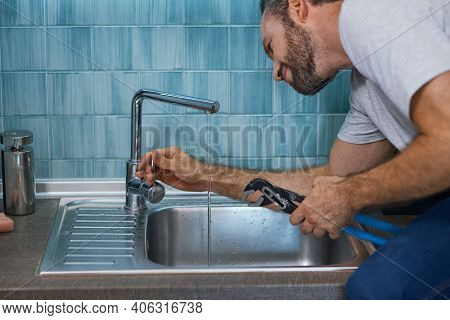 Fix A Leak. Close Up Shot Of Professional Repairman Using Pipe Wrench While Examining And Fixing Fau
