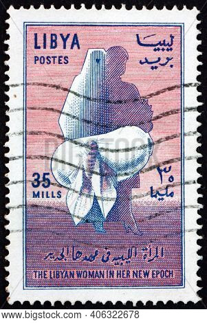 Libya - Circa 1964: A Stamp Printed In Libya Shows Moth Emerging From Cocoon, Veiled And Modern Wome