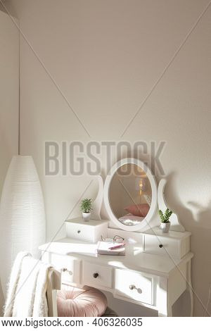 Detail of makeup dressing table with large mirror, diary and organizer. White and clean workstation in the master bedroom. Nobody inside.