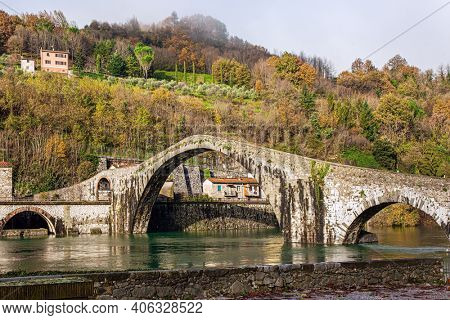  Picturesque stone bridge of magnificent architecture built a thousand years ago. Devil's Bridge over the Sercchio River. Cold windy winter day. Travel to fabulous Italy