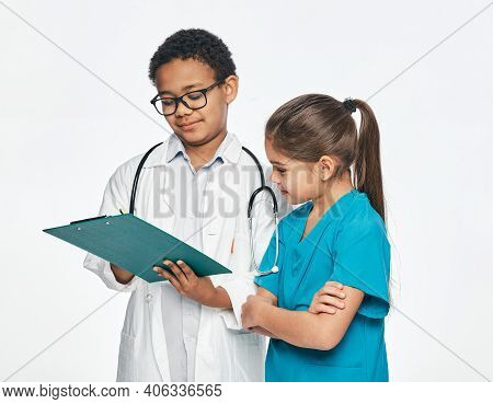Two Children Play Medical Staff And Choose A Medical Profession. Consilium Of A Boy Practicing Docto