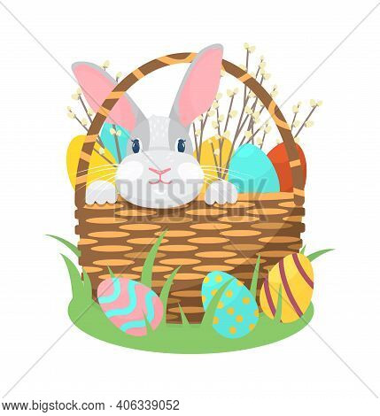 Cute Easter Bunny Sitting In A Basket With Easter Eggs And Willow Branches Isolated.