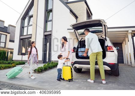 Proto Portrait On Full Family With Small Kids Put Baggage Suitcases In The Car Smiling Together Befo