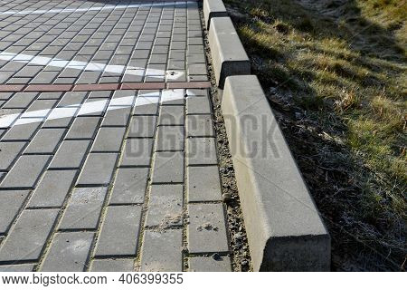 Installation Of Concrete Curbs With Gaps That Let Water Into The Park Into The Ditch, Where It Seeps