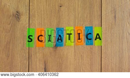 Sciatica Symbol. Concept Word 'sciatica' On Colored Papers On A Beautiful Wooden Background, Copy Sp