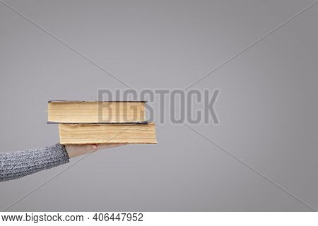 Stack Of Old Books In The Palm Of An Invisible Person