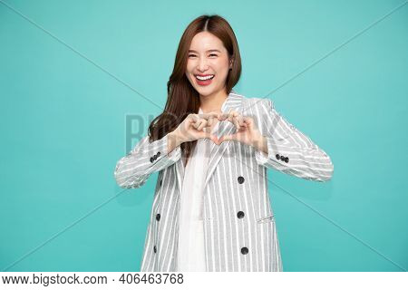 Asian Business Woman In Suit Showing Heart Sign Isolated On Green Background, Speading Love And Happ