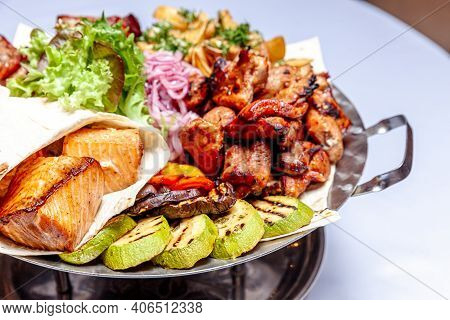 Mixed Grill Meat Fried Vegetables And Grilled Salmon Fish Fillets Decoration In Warm Dish. Assorted