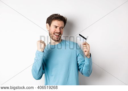 Happy Man Dancing With Plastic Credit Card, Smiling And Saying Yes, Celebrating On White Background