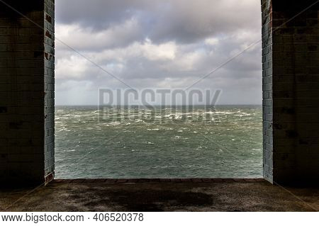 Window Frame In Derelict Building Looking Out To Stormy Sea.