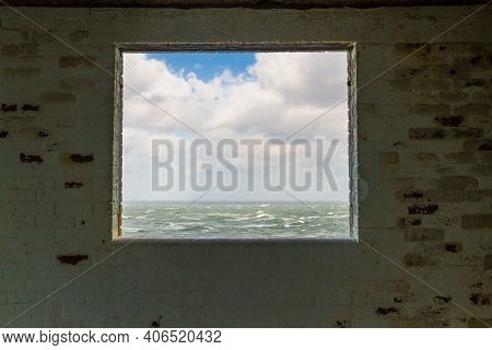 Window Frame In Derelict Building Looking Out To Stormy Sea.