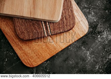Set Of Wooden Cuttng Boads On Black Background. Wooden Kitchen Block Close Up.