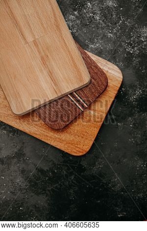 Set Of Wooden Cuttng Boads On Black Background. Wooden Kitchen Block Close Up.