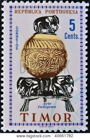 TIMOR - CIRCA 1961 : Un timbre imprimé en spectacles de Portugal un une pièce d'artisanat indien, montrant les trois e