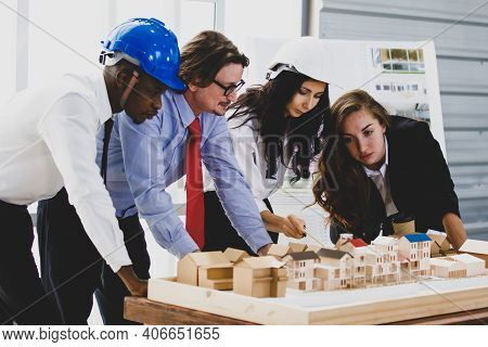 A Man African American Engineering And Caucasian Holds Coffee. In Group Meetings Viewing A Model Bui