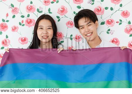 Lgbtq Couple Lovers, A Handsome Girl As A Man Or Butch Femme Holding The Rainbow Flag The Symbol Of 