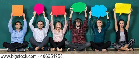 Group Of Six Business People Team Sittiing Together And Holding Colorful And Different Shapes Of Spe