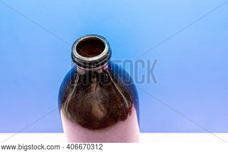 Old Edible Oil Storage Glass Bottle On Blue Background