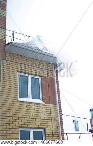Snow Is Falling From The Roof Of A Multi-storey Building.