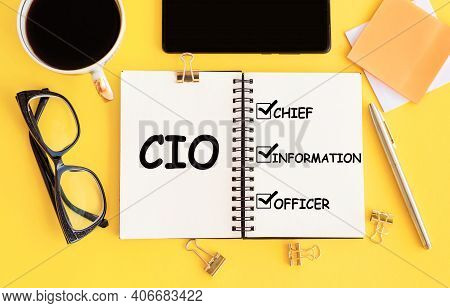 Cio - Chief Investment Officer, Text On Notepad And Office Accessories On Yellow Desk.