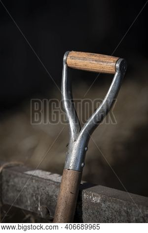 Wooden Handle Of A Tool On A Farm Against A Metal Gate In A Hay Barn In The Netherlands