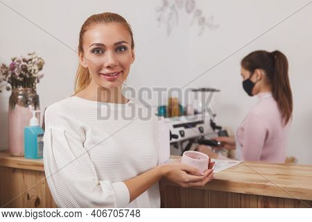 Woman Smiling To The Camera, Enjoying Coffee At The Cafe During Coronavius Pandemic
