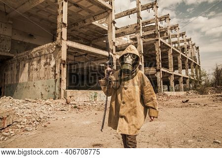 Boy Stands With A Gun In His Hand. Boy In A Gas Mask. \ra Young Man In A Protective Cloak And Hood. 