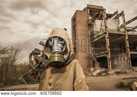 Boy Stands With A Gun In His Hand. Boy In A Gas Mask. \ra Young Man In A Protective Cloak And Hood. 