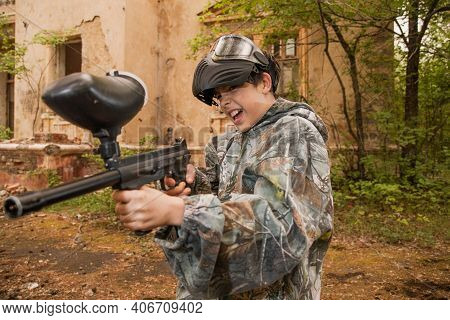 Boy Stands With A Gun In His Hand. Boy In A Gas Mask. \\ra Young Man In A Protective Cloak And Hood.